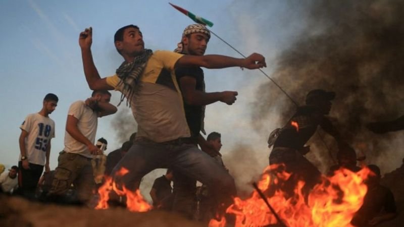 পাথর ছুঁড়ে ফিলিস্তিনি তরুণরা লড়ছে ইসরায়েলি সৈন্যদের বিরুদ্ধে